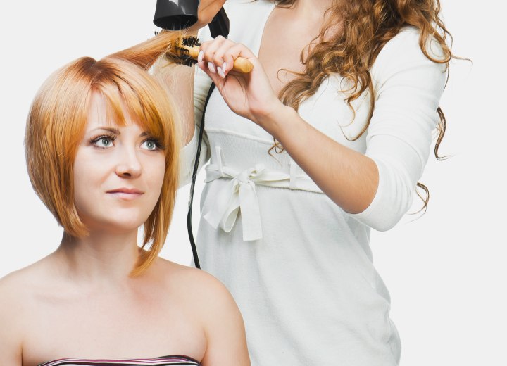 Hair stylist and a salon client wearing her hair in an angled bob