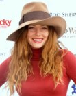 Bijou Phillips sporting a boho look with long wavy hair and a hat