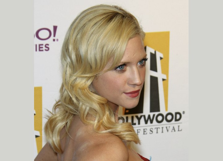 Brittany Snow with her long hair in a bouncy style with large curls and