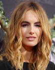 Camilla Belle sporting a classic long hairstyle with waves