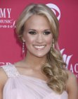 Carrie Underwood's layered hair styled into a side ponytail