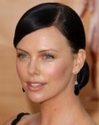 Charlize Theron with her hair sleeked back and gathered in a bun