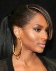 Ciara with her smooth hair brought back into a timeless ponytail