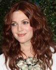 Redhead Drew Barrymore wearing her hair long with a middle part and waves