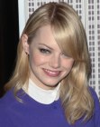Emma Stone sporting a long casual style with her hair tucked behind one ear