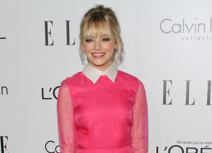 Emma Stone wearing a pink dress with white collar and cuffs