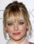 Emma Stone wearing her hair in a loose up-style with tendrils along the face