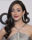 Emmy Rossum's long hairstyle with loose curls styled in front of the shoulder