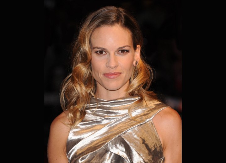 Hilary Swank with her hair in waves and wearing a shimmery silver dress