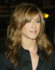 Jennifer Aniston with curled golden brown hair and side bangs