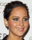 Jennifer Lawrence with her hair slicked back in a bun for a pixie look