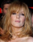 Kelly Reilly sporting a shoulder length haircut with bangs that veil her eyes