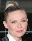 Kirsten Dunst with her hair styled up in a tight bun