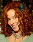 Kristen Dalton wearing her red hair in spiral curls and with a bow accessory