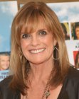Linda Gray aged almost 70 and wearing her hair long with fluffy bangs