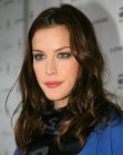 Liv Tyler with her hair styled with a middle part and waves