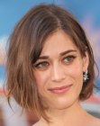 Lizzy Caplan sporting a bob haircut with one side tucked behind the ear