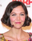 Maggie Gyllenhaal sporting a chin length bob with bouncy curls