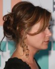 Maura Tierney with her hair styled into a messy chignon