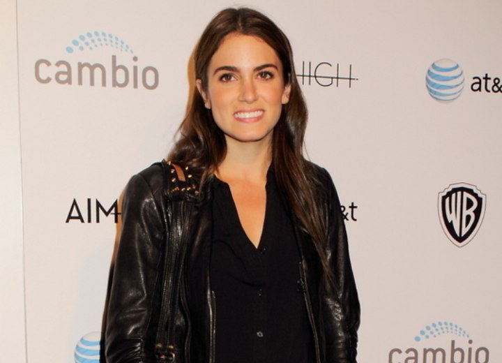 Nikki Reed wearing a black shirt, leather jacket and riding boots