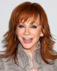 Reba McEntire aged over 50 and wearing long hair with curled ends