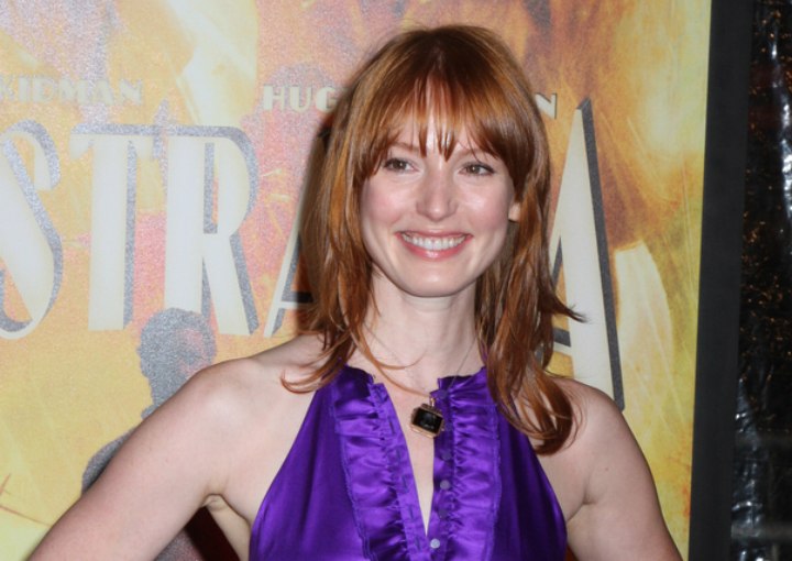 Alicia Witt's red hair with bangs and a purple dress