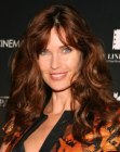 Carol Alt's long hairstyle with a high parting and bouncing curls and waves