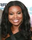 Gabrielle Union wearing her black hair long with curls and a middle part