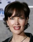 Janine Turner's short layered hair with the sides tucked behind the ears