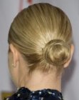 Maria Bello wearing her hair pulled back and gathered in a bun