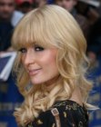 Paris Hilton sporting bangs and curls that plunge below the shoulders