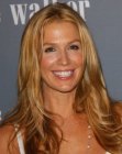 Poppy Montgomery with her hair in a long layered style with curled ends