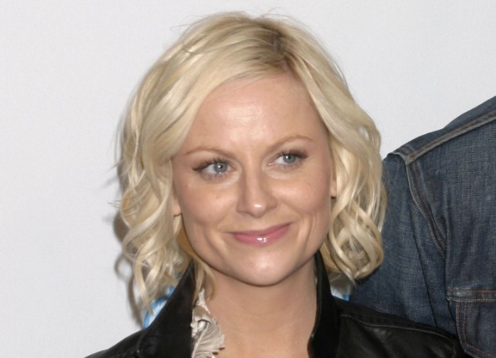 Amy Poehler wearing a curly neck length bob with side parting