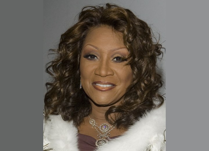 PATTI LABELLE wearing long curly tresses, possibly a wig