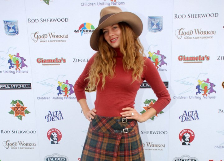 Bijou Phillips wearing a turtleneck, skirt and boots