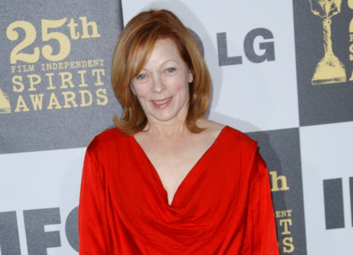 Frances Fisher wearing a silky red loose neck blouse