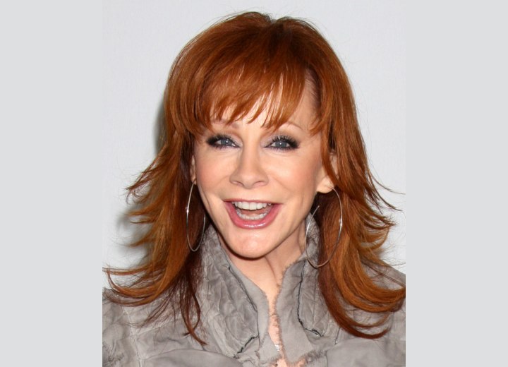Reba McEntire wearing her red hair in a long chiseled style