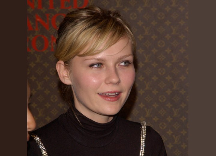 Kirsten Dunst wearing a turtleneck and with her short hair styled in a diagonal line