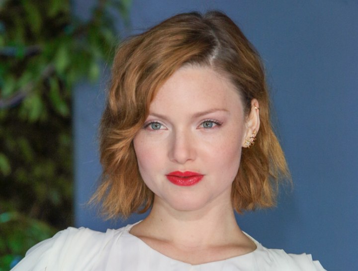 Holliday Grainger wearing her hair short in a curly bob