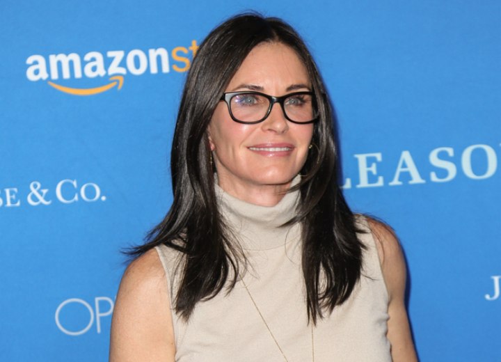 Courteney Cox wearing a turtleneck and black glasses