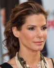Sandra Bullock with her hair styled in a ponytail with curls
