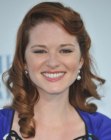 Sara Rue with her reddish hair styled into spiral curls