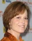 Sigourney Weaver's short hairstyle with the back touching her collar