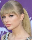 Taylor Swift with bangs and her hair pulled back into a ponytail