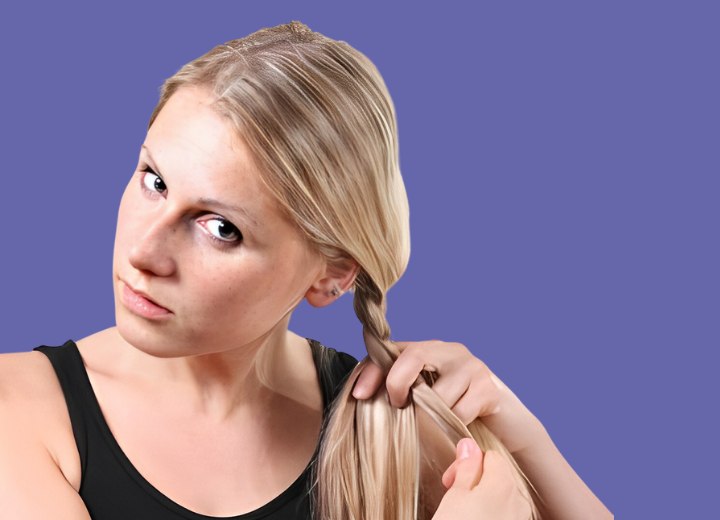 Young lady who is braiding her own hair