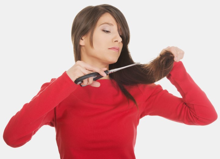 Woman cutting her own hair with household shears