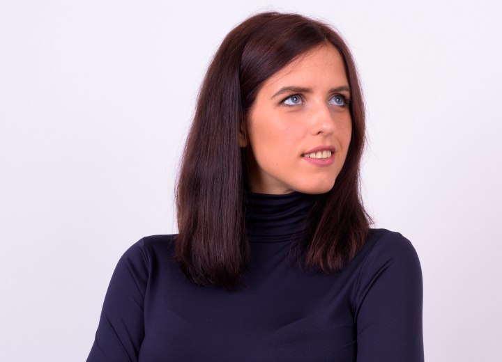 Girl with shiny dark brown hair and wearing a blue turtleneck
