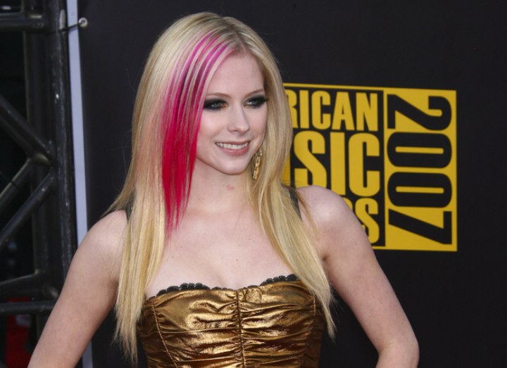 Avril Lavigne with blonde hair and a pink highlight