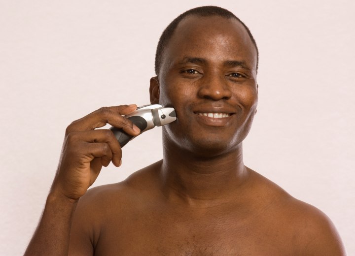 Black man with an electric razor