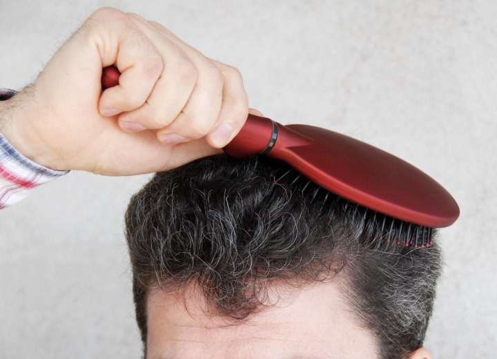 Man brushing his graying hair